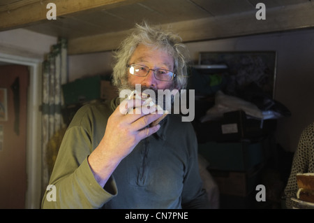 Ein 70 jähriger Mann Essen ein Stück Kuchen Stockfoto