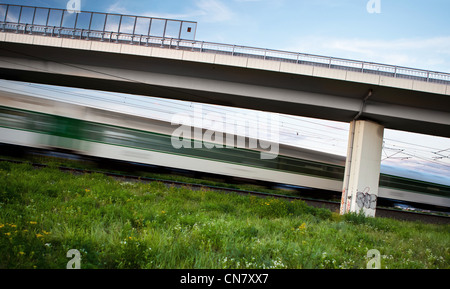 Schnellzug Sommerlandschaft schnell durchlaufen und Weitergabe unter einer Autobahnbrücke Stockfoto