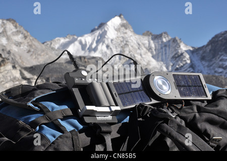 Solar-Ladegerät aufladen der Kamera im Himalaya, ruht auf einem Bergsteiger-Rucksäcke Stockfoto