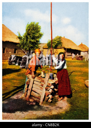Zuerst veröffentlicht 1914 russischen Bauern traditionelle ethnische Kleidung Kostüm Kleid an einem Brunnen Stockfoto