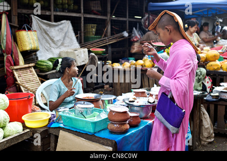 Eine Nonne erhält ein Geschenk von Lebensmitteln in einem Rangun Straßenmarkt (Rangun), Burma (Myanmar) Stockfoto