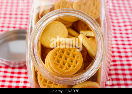 Runde Kekse in einer Glasvase auf einem weißen und roten Tuch Stockfoto