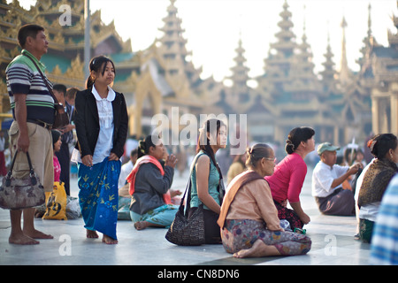 Birmanische Frauen beten den heiligen buddhistischen Stätten der Shwedagon Paya, Yangon (Rangoon), Myanmar (Burma) Stockfoto