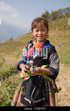 Porträt eines lächelnden Black Hmong Hügel Stamm Mädchens mit Wildblumen, Lao Chai Dorf in der Nähe von Sapa-Stadt, Vietnam Stockfoto