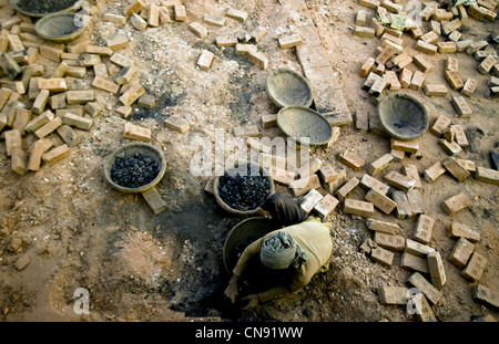 Mann, Einnahme von verbrannte Spule bei Fatullah Ziegelei, Bangladesch Stockfoto