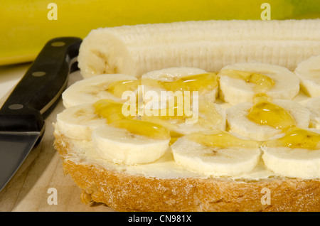 Scheibe Brot mit Bananenscheiben und Honig Stockfoto