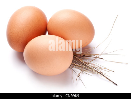 Eiern mit einem Strohhalm auf weißem Hintergrund. Stockfoto