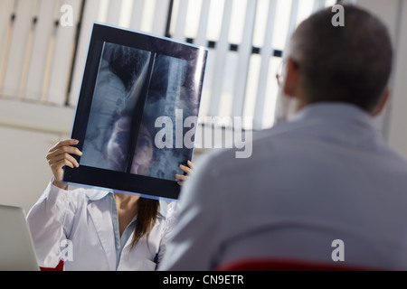 Mitte Erwachsene Frau bei der Arbeit als Arzt in Büro- und Untersuchung Röntgenstrahlen mit Patienten Stockfoto