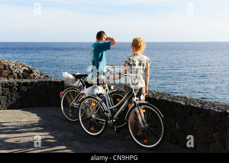 Lanzarote, Kanarische Inseln - Playa del Carmen. Paar mit Fahrräder einkaufen Ausschau auf das Meer. Stockfoto