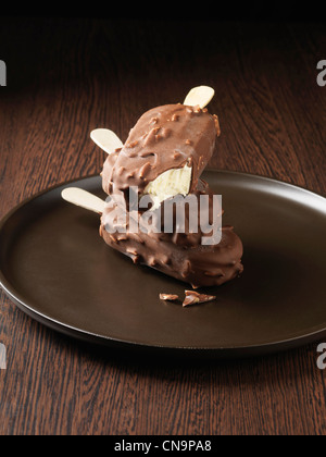 Eiscreme-Riegel auf Holzplatte getaucht Stockfoto