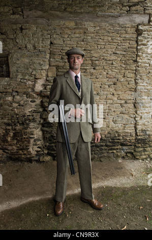 Älterer Mann mit Gewehr über seinen arm Stockfoto