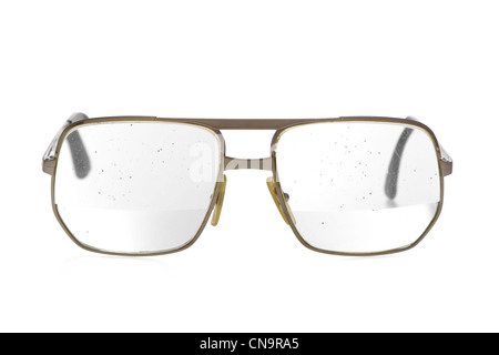 Sehr alt, schmutzig, klapprigen Brillen mit dicken Bifokallinse in gold Metallrahmen. Brille des älteren Menschen. Gesprenkelte Schmutz auf der Linse. Stockfoto