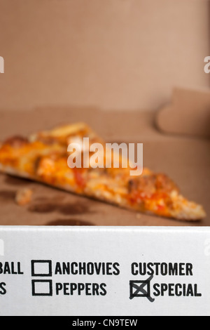 Scheiben von Buffalo Chicken Pizza links im Feld markiert besondere Kunden. Geringe Schärfentiefe mit Fokus auf den Text. Stockfoto