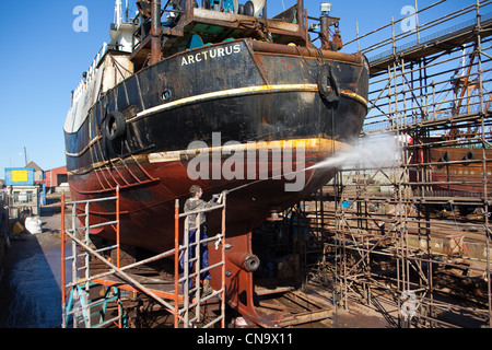 Spay Reinigung der Trawler Rumpf auf den Helgen, in Reparatur Yards am Hafen Peterhead Schottland Großbritannien Stockfoto