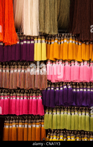 Seidene Fäden/Quasten hängen zum Verkauf in einem Kurzwaren Souk, Marrakesch, Marokko, Nordafrika Stockfoto