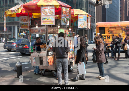 Eine Straße Verkäufer Warenkorb Verkauf von Hot Dogs und andere Lebensmittel Werke der Ecke 5th Avenue und 42nd Street in New York City. Stockfoto