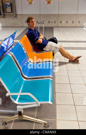 Junge männliche westliche Touristen warten auf bunten Sitze für Metro u-Bahn in Kaohsiung Taiwan. JMH5969 Stockfoto