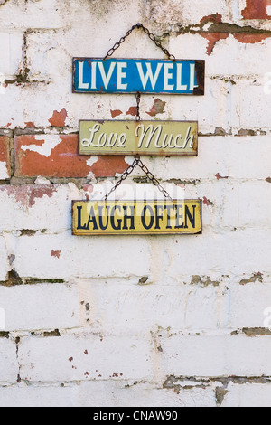 Leben Sie, lieben Sie, lachen Sie Zeichen auf einer alten Mauer. Stockfoto