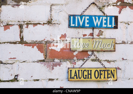 Leben Sie, lieben Sie, lachen Sie Zeichen auf einer alten Mauer. Stockfoto