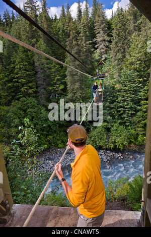 Man zieht Wanderer über die Hand-Straßenbahn Gewinner Creek in der Nähe von Girdwood, Alaska Yunan, Sommer Stockfoto