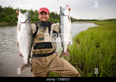 Fliegenfischer hält zwei Sockeye Lachs am Fluss Mulchatna in der Bristol Bay, Südwest-Alaska, Sommer Stockfoto