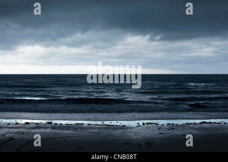 Wellen, die am Sandstrand Stockfoto