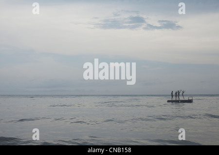 Freunde spielen auf Schwimmdock in See Stockfoto