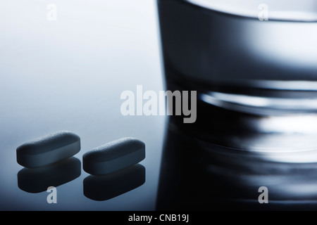 Nahaufnahme von Pillen auf reflektierende Oberfläche Stockfoto