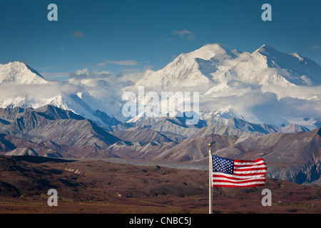 Eine amerikanische Flagge fliegt im Wind im Eielson Visitor Center mit Mt. Mckinley im Hintergrund, Denali-Nationalpark, Alaska Stockfoto