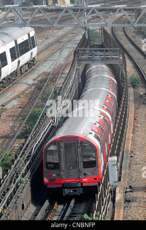 Londoner u-Bahn Zug eingeben Tunnel unter oberirdischen Gleisen Stockfoto