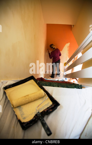 Lady, Frau Dekoration Halle und Treppe Malerei Wände mit Bürstenwalze in der Nähe, Farbe zu ändern Stockfoto