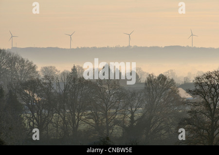 Landschaft im Winter Windenergieanlagen im Hintergrund (Norden Mayenne, Pays de la Loire, Frankreich, Europa). Stockfoto