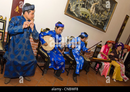 Horizontale Ansicht einer traditionellen vietnamesischen Truppe der Musiker spielen und singen traditionelle Volkslieder in Tracht. Stockfoto