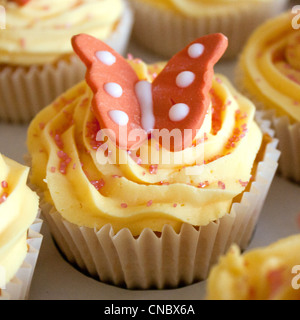 Aus nächster Nähe erschossen, ein Schmetterling Cupcake, schön vereist und dekoriert. Stockfoto