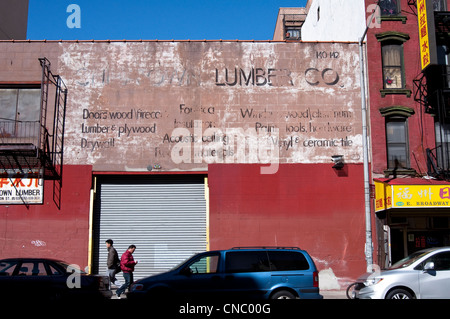 Ein alter Hase malte Werbung [Geist Zeichen] für Chinatown Lumber Co. am East Broadway in Chinatown, New York City, USA. Stockfoto