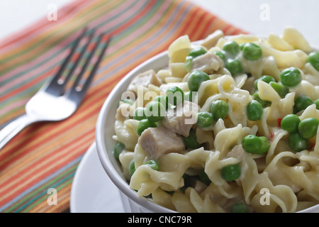Eine Nahaufnahme von einem Gedeck einer Schüssel Huhn Ala König mit Erbsen. Stockfoto