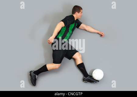 Mann in Uniform dribbling den Ball auf grauem Hintergrund isoliert Stockfoto