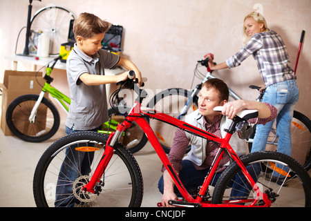 Porträt von niedlichen jungen und seinem Vater Reparatur Fahrrad in garage Stockfoto