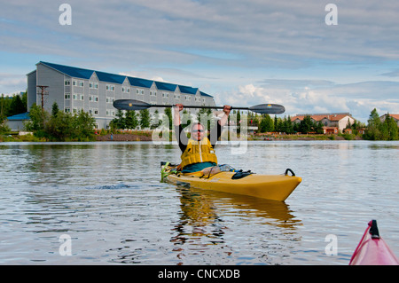 Mann wirft seine Arme im Triumph nach dem Paddeln die Chena River in Fairbanks, Alaska Interior, Sommer Stockfoto