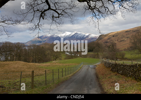 Feldweg und Schnee begrenzt Bergen oberhalb von Derwent Water im Lake District, Cumbria, UK Stockfoto