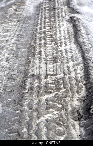 Spuren von Pkw-Reifen auf der nassen Felder Straße Stockfoto