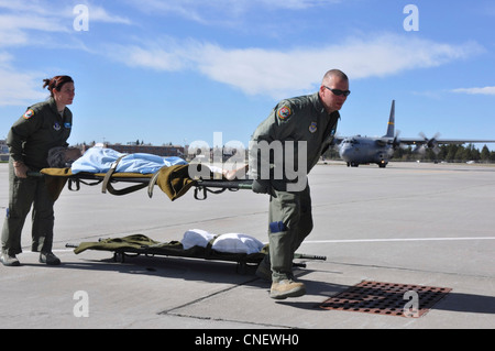 Wyoming Air National Guardsmen 2. LT. Michael Ryan aus Greeley, Colorado, und 1. LT. Jodi Smith aus Bridgeport, NB., laden einen simulierten Patienten an Bord eines C-130-Frachtflugzeugs auf der Wyoming Air National Guard Base in Cheyenne, Wyo., 13. April 2012, für eine Trainingsmission. Beide Leutnants sind Flugschwestern mit Wyomings 187. Aeromedical Evacuation Squadron. Die Einheit ist spezialisiert auf die Bereitstellung von Rettungsdiensten an Bord von Luftwaffenfrachtflugzeugen, die Kranke und Verwundete aus Kampfgebieten an sicherere Orte transportieren. Stockfoto