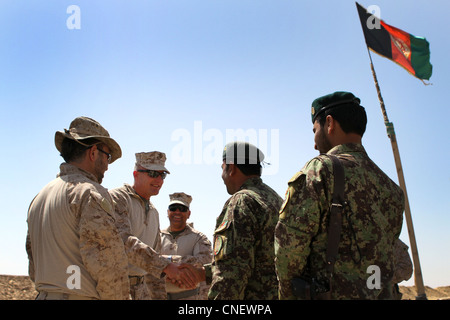 U.S. Marine Col. Roger Turner, der Kommandant der Regimental Combat Team 5, begrüßt den afghanischen Nationalarmee Col. Mohammad Sarwar Kushal, die 1. Brigade, den Exekutivoffizier des 215. Korps, während einer Reise zu mehreren Kampfposten und Patrouillenbasen im Bezirk Marjah der Provinz Helmand, 4. April 2012. Stockfoto