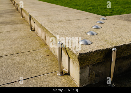 Anti-skateboarding Geräte installiert auf einer niedrigen Steinmauer Stockfoto