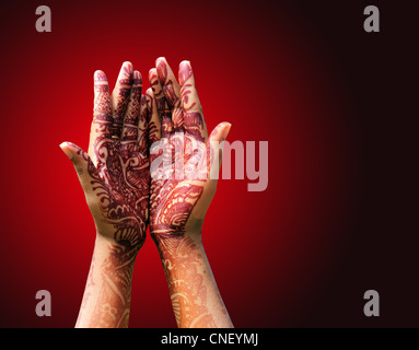 Schöne Henna oder Mehendi Dekoration auf einem hindu Braut Hand mit rötliche Hintergrund mit Textfreiraum. Stockfoto