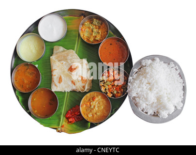 Südindische Teller Essen auf Bananenblatt isoliert auf weiss. Traditionelle vegetarische gesunde indisches Essen mit Vielzahl von Currys, Stockfoto