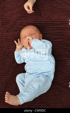 Ein neugeborenes Baby junge liegend auf einer Decke, wird auf seine Schwester gerichtet. Stockfoto