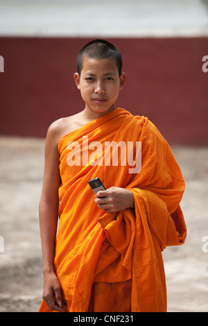 Junge Novizin Roben buddhistischer Mönch in Safran mit einem Mobiltelefon. Stockfoto