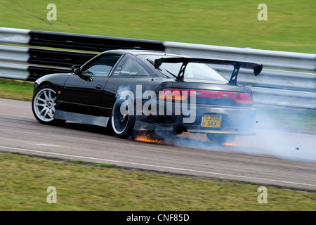 Auto driften bei Lydden Hill Race Circuit Track Kent England Dover Rauchen Funken fliegen Nissan 200SX Schreddern Rubber Stockfoto