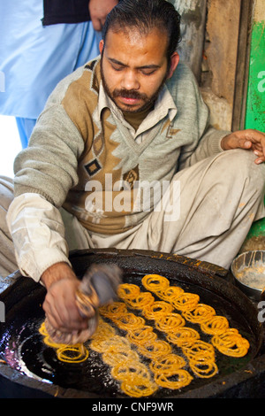 Verkäufer machen gebratene Süßigkeiten in Islamabad, Pakistan Stockfoto